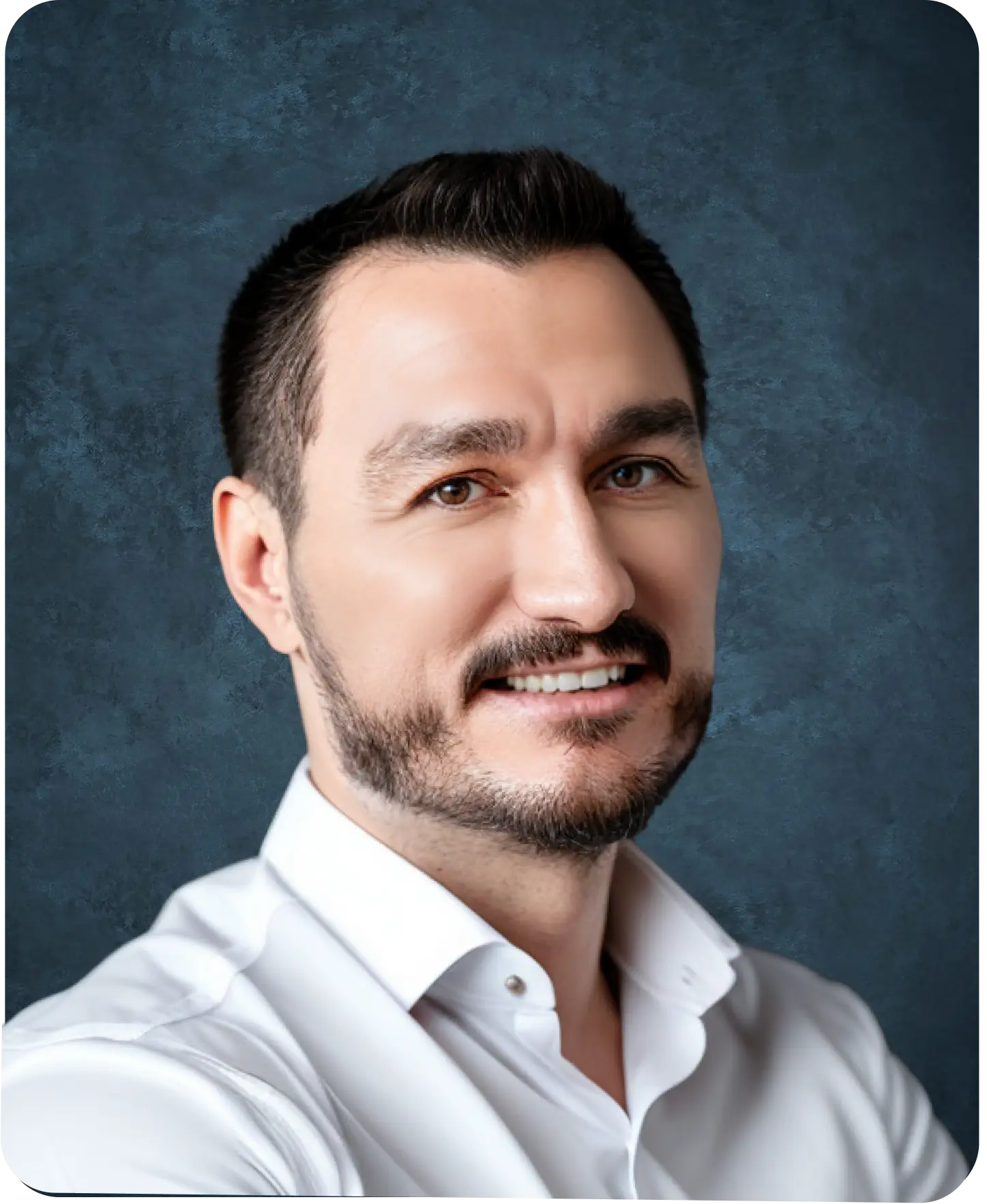 Professional headshot of Kyle Vance, a web developer, with short dark hair and a trimmed beard, smiling in a white collared shirt against a dark textured background.